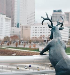 socha soba sedícího na zábradlí