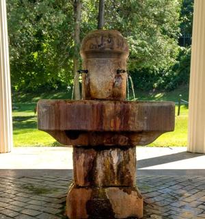 a water fountain in the middle of a park
