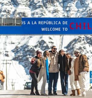 skupina lidí stojící pod modrou dopravní značkou