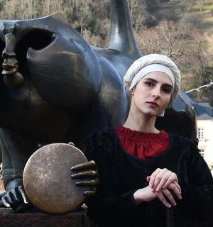 en kvinde står foran en statue