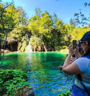 a woman taking a picture of a river with a camera