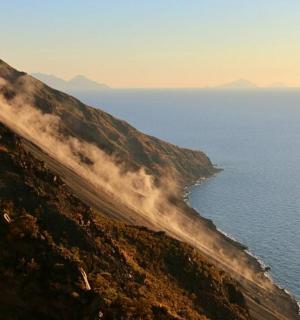 ein Feuer an der Seite eines Berges neben dem Meer