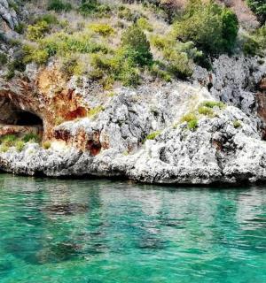 skalnaté pobřeží s tyrkysovou vodou před ním