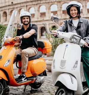 a man and a woman riding on an orange scooter