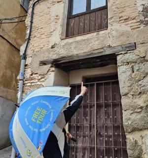a person with an umbrella standing in front of a building