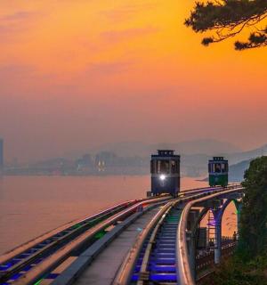 日落时分，一列火车在水边的轨道上行驶