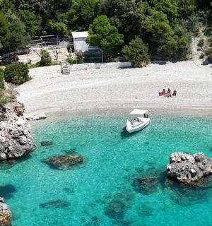 loď ve vodě poblíž pláže s kameny