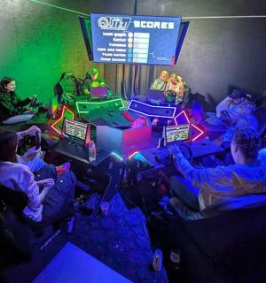 skupina lidí sedících v místnosti s počítači