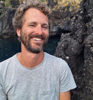 a man standing next to a body of water