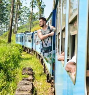 a man looking out the window of a blue train
