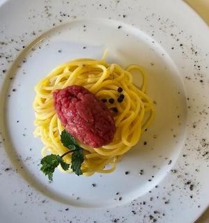 a plate of pasta with a piece of meat on it
