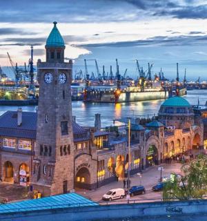 a building with a clock tower next to a river