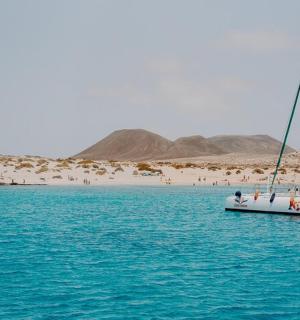a boat in the water with a beach in the background