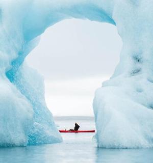 冰山前的皮划艇上的一个人
