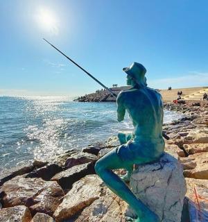 一名男子在海滩上钓鱼的雕像