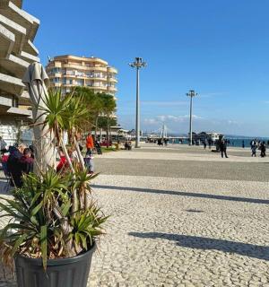 a street with people sitting in chairs and a building
