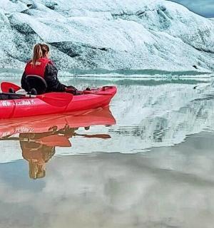 Muž a žena sedící na červeném kajaku na vodě