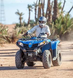 一名男子在土路上骑着四轮车