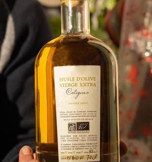 一个人拿着一瓶葡萄酒品尝