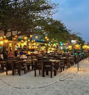a row of tables and chairs on a beach