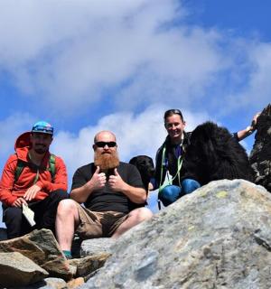 三个男人坐在山顶上