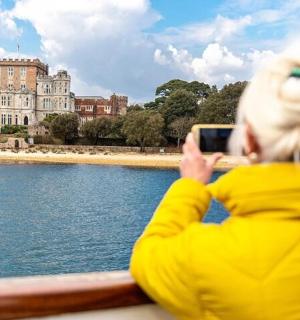 a person taking a picture of a building on the water