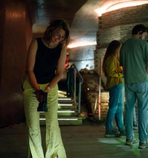 a woman standing in a room holding a camera