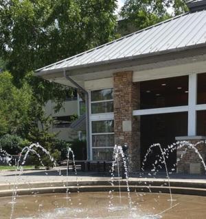 dvě děti si hrají ve fontáně před budovou