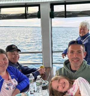 skupina lidí sedících u stolu na lodi