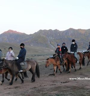 a group of people riding horses in a field