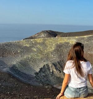 žena sedící vedle velkého kamene