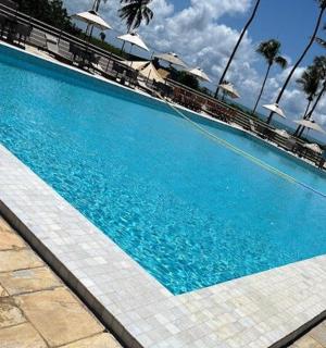 一个配有椅子和遮阳伞的大型蓝色游泳池