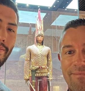 two men standing in front of a statue of aaraoh