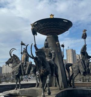 a statue of horses on a fountain in a city