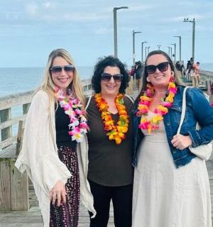 tři ženy pózující pro fotografii na molu