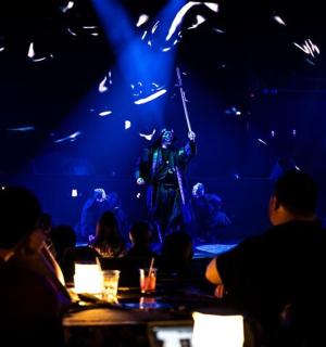 a group of people sitting at a table watching a performance