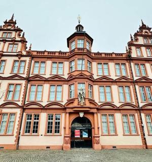 a large pink building with a statue in front of it