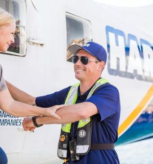 一名女子在飞机前与一名男子握手