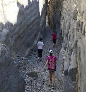 a group of people walking through a rocky canyon