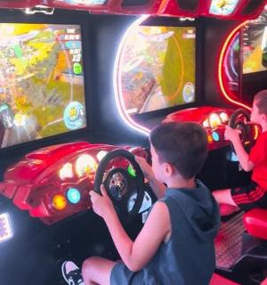 two young boys playing a video game in a car