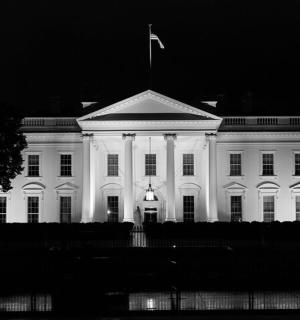 bílá budova s vlajkou na střeše