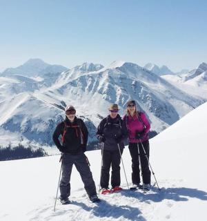 drei Personen stehen auf einem schneebedeckten Berggipfel