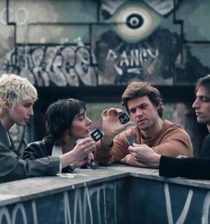 一群人坐在桌边看着手机