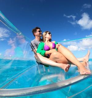 一男一女坐在水中的玻璃船上