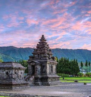 a stone monument in a park with a cloudy sky