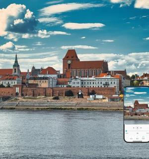 a cell phone in front of a city with a river