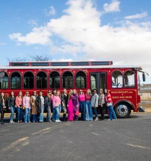 一群人站在一辆红色巴士前