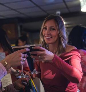 skupina lidí stojících a dívajících se na mobilní telefon