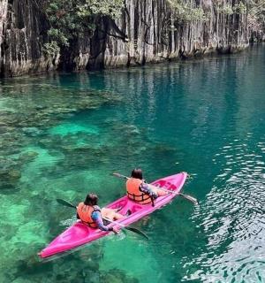 zwei Personen in einem rosa Kajak im Wasser