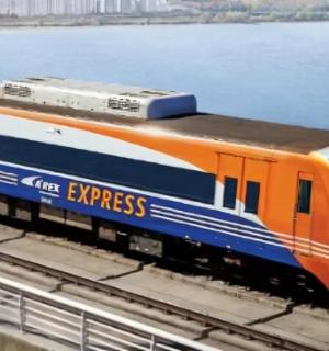 oranžový a modrý vlak na kolejích u vody